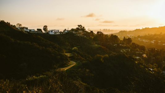 a sunset over a hill